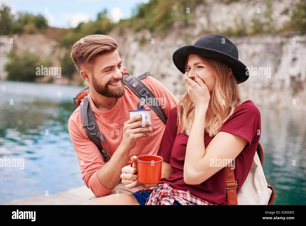 Paar, das durch Wasser holding Emaille Becher lächelnd, Krakow, Malopolskie, Polen, Europa Stockfoto