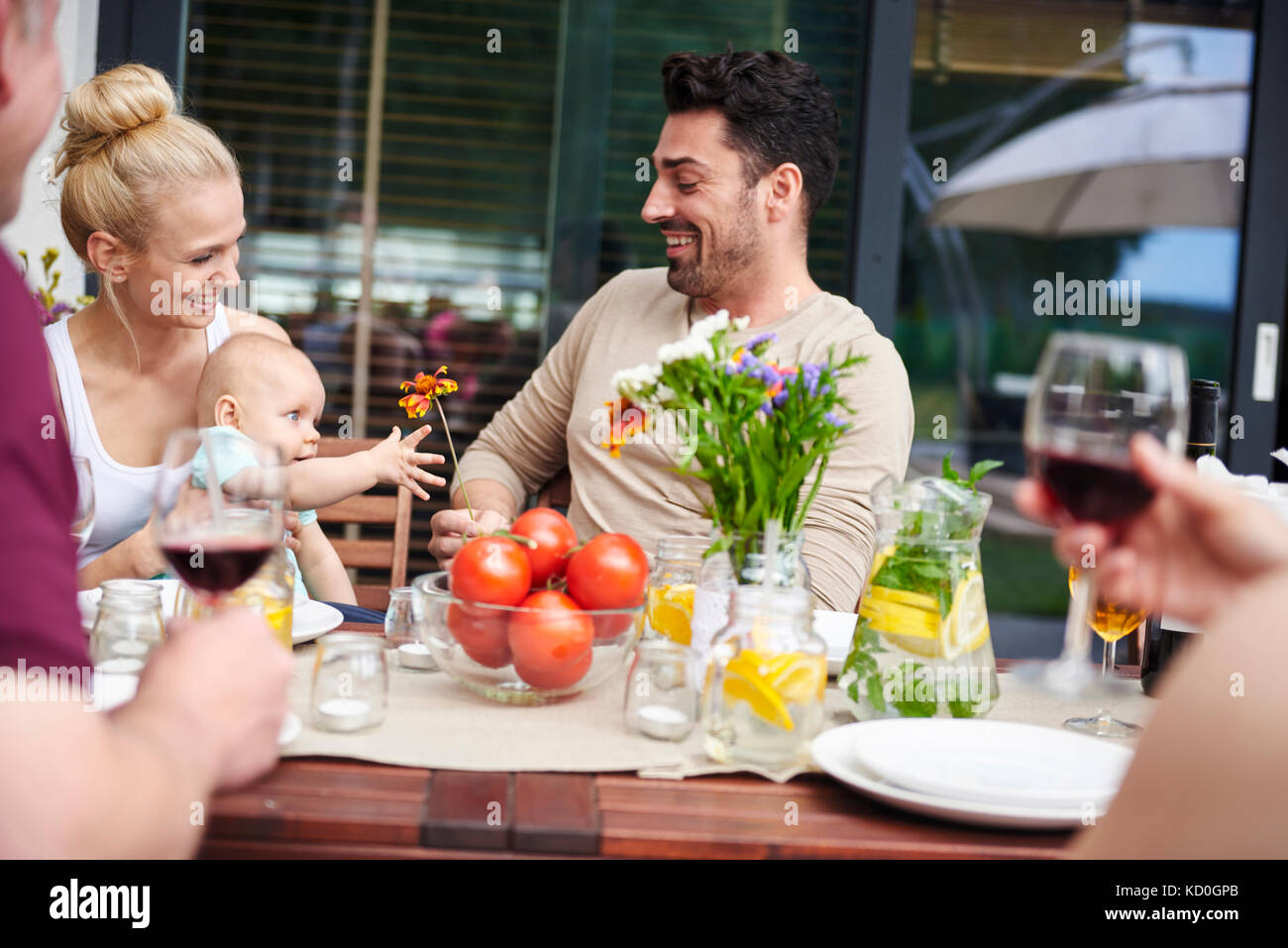 Paar mit Baby Tochter an Familie Mittagessen auf der Terrasse Tisch Stockfoto