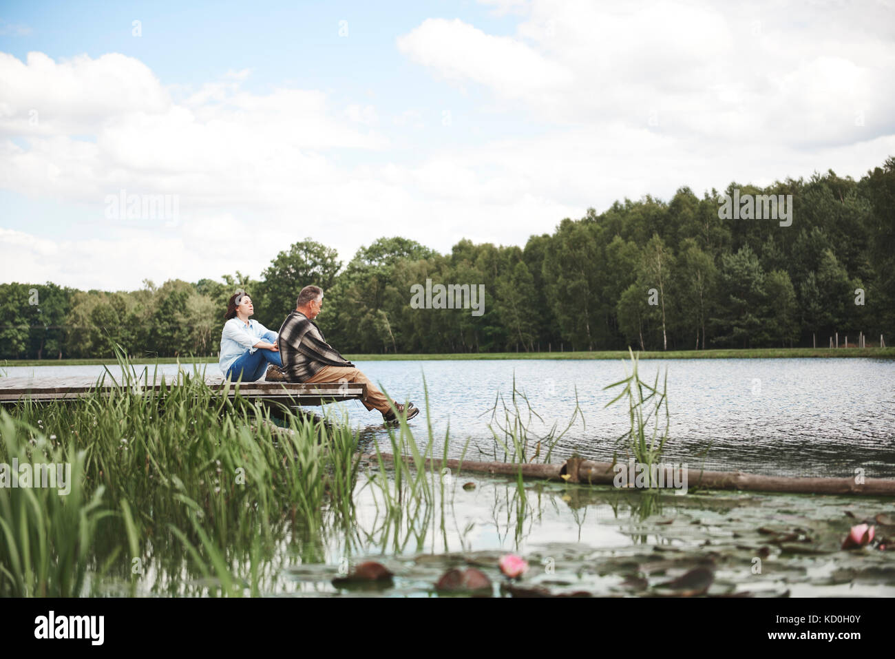 Reifes Paar entspannend auf Steg am See Stockfoto
