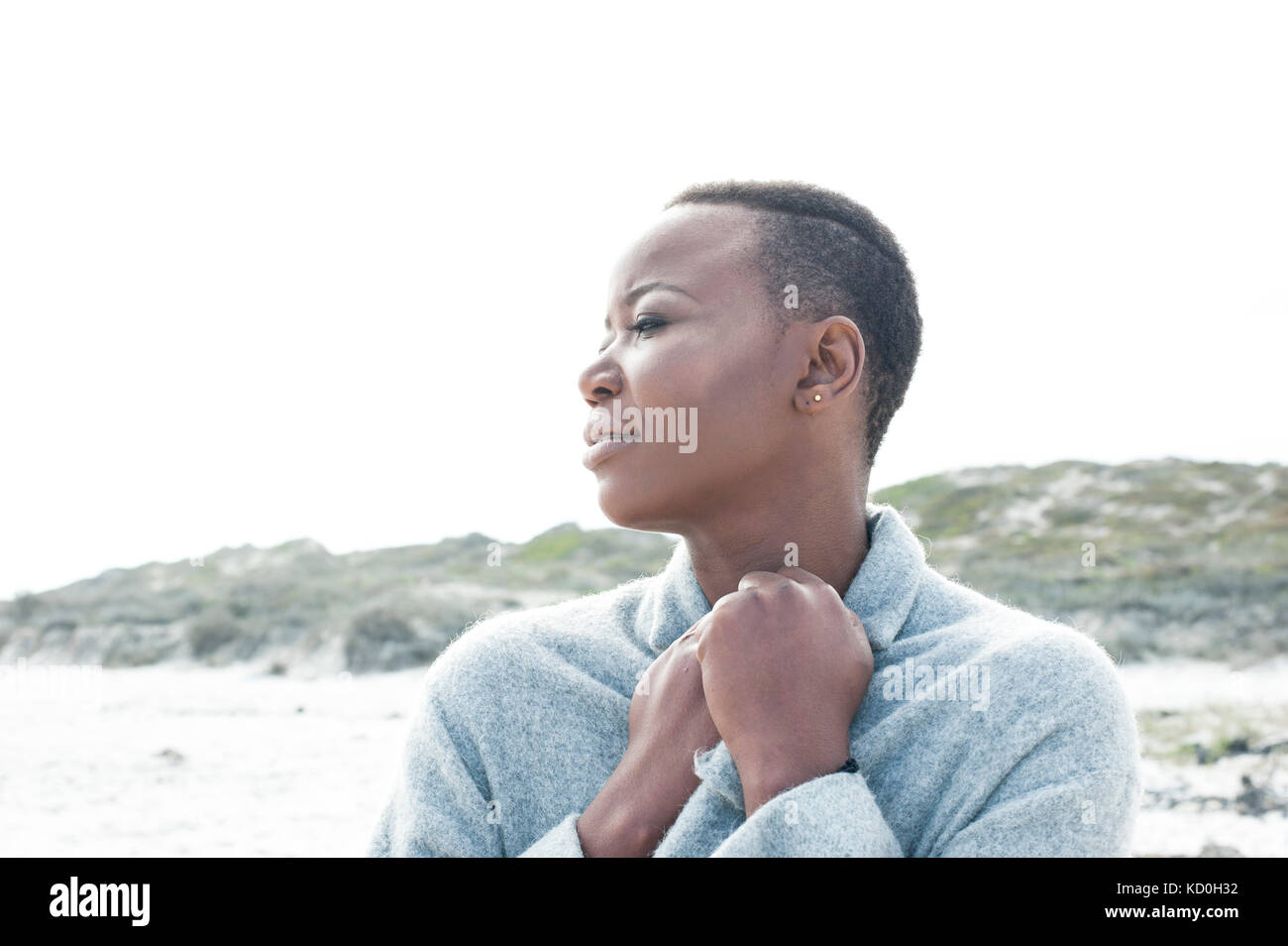 Junge Frau am Strand, mit Aussicht suchen, gefalteten Händen Stockfoto