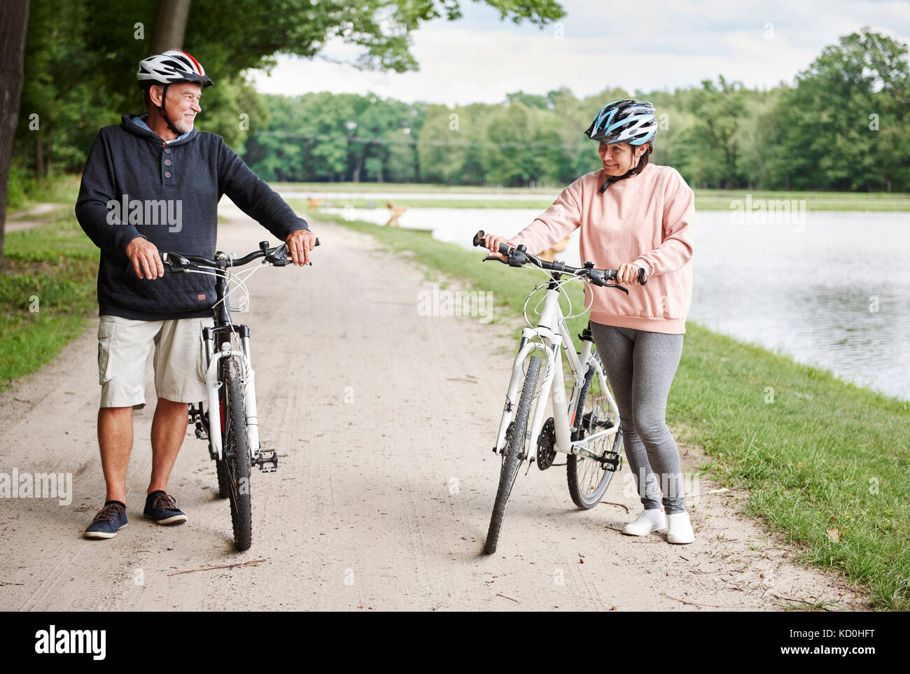 Reifes Paar entlang des ländlichen Weg mit Fahrrädern, lächelnd Stockfoto