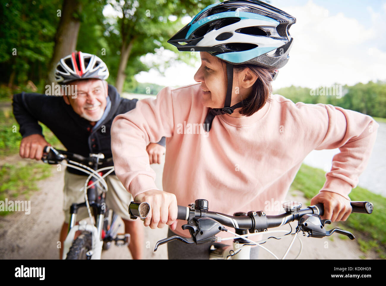 Reifes Paar Radfahren am See, Lachen Stockfoto