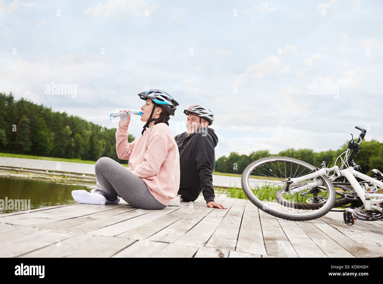 Reifes Paar entspannend auf Jetty, Fahrräder neben Ihnen Stockfoto