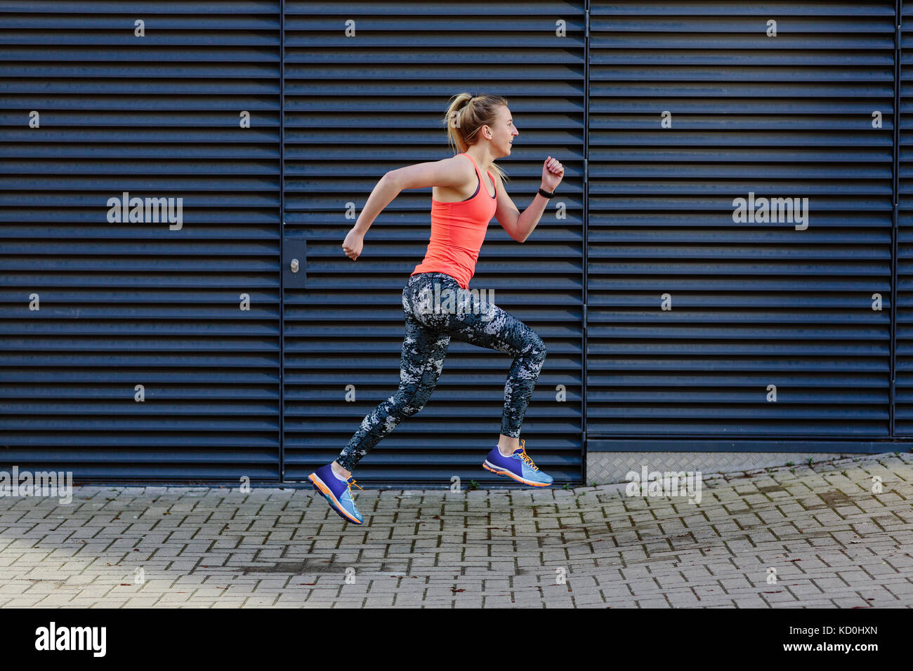 Junge Läuferin Geschwindigkeit entlang Bürgersteig laufen Stockfoto
