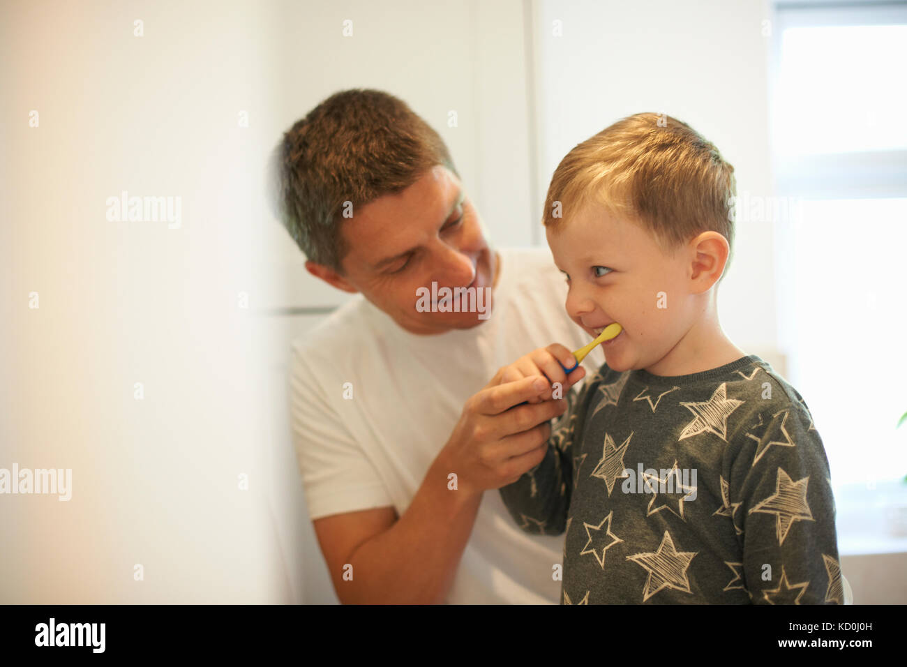 Reifer Mann, Sohn, wie Zähne im Badezimmer zu putzen Stockfoto
