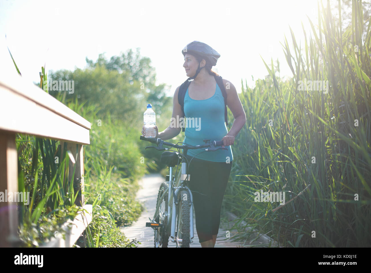 Radfahrer zu Fuß mit dem Fahrrad auf den Weg durch hohes Gras Stockfoto