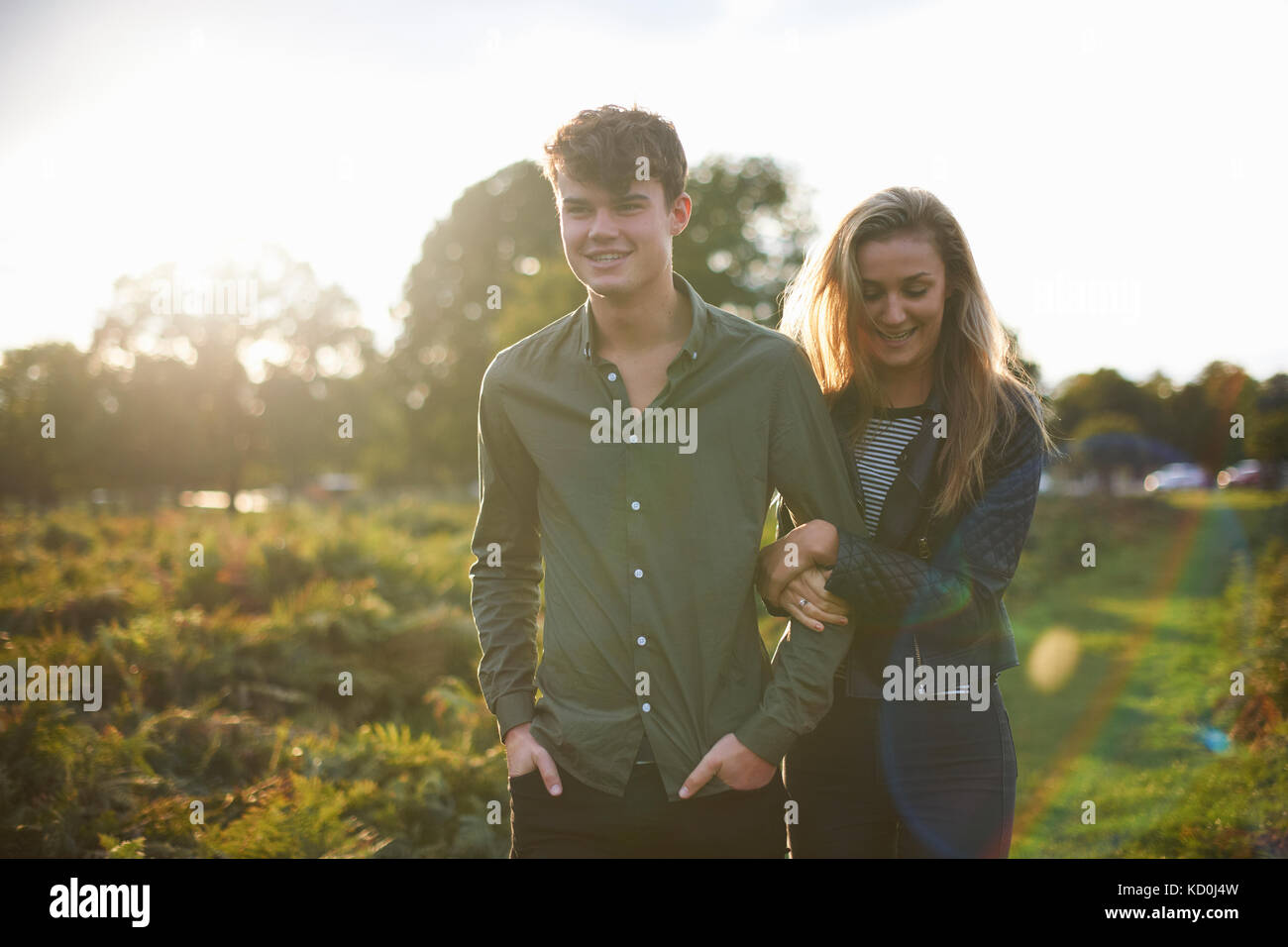Junges Paar schlendern Arm in Arm im Feld Stockfoto