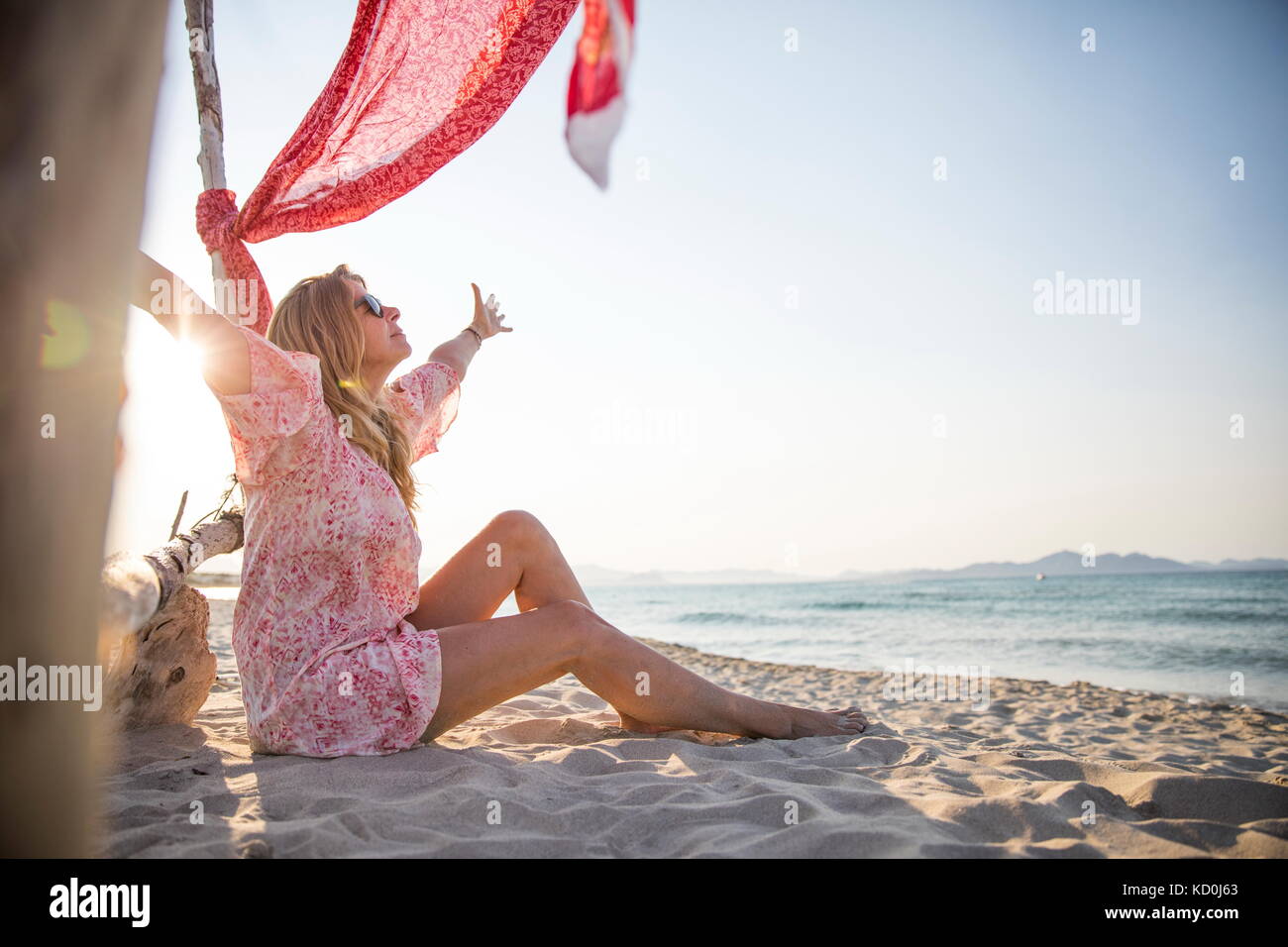 Frau sitzt am Strand, Arme offen, Palma de Mallorca, Balearen, Spanien, Europa Stockfoto