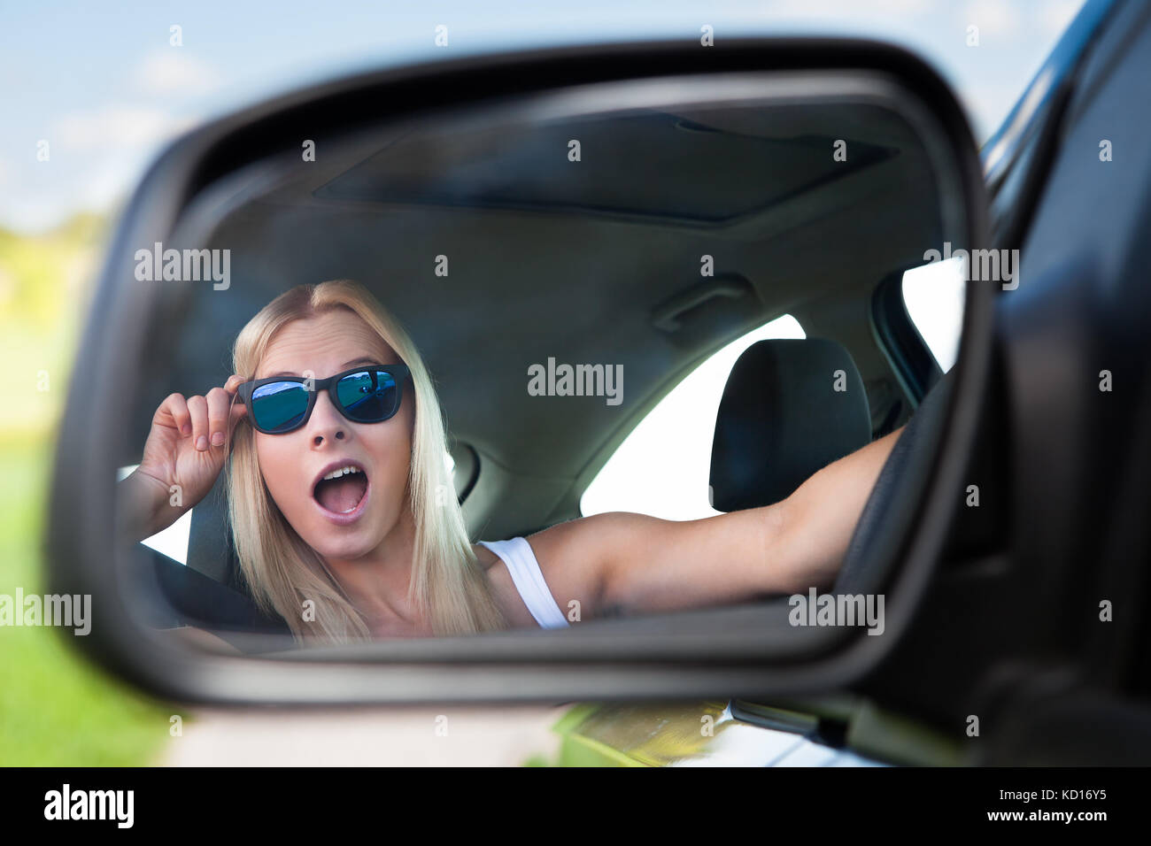 Junge Blonde Frau mit Sonnenbrille fahren Auto Stockfoto