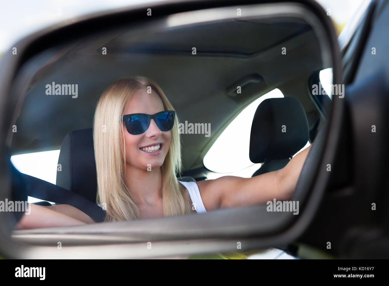 Junge Blonde Frau mit Sonnenbrille fahren Auto Stockfoto