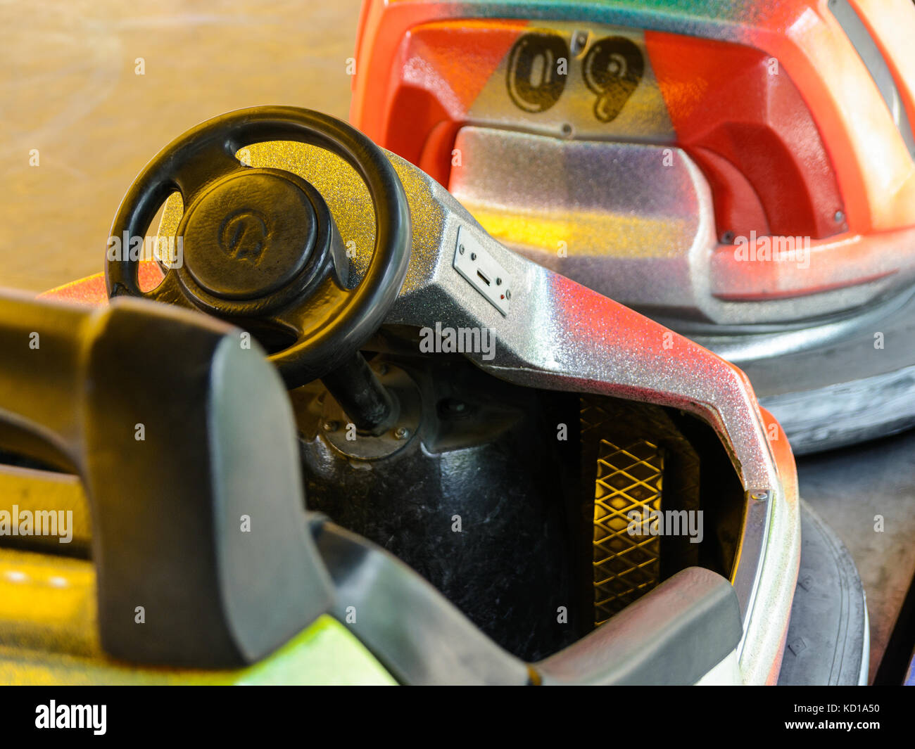 Blick auf das Cockpit eines bunten dodgem Auto mit Lenkrad, Pedale und Münze Steckplatz in einem Vergnügungspark. Stockfoto