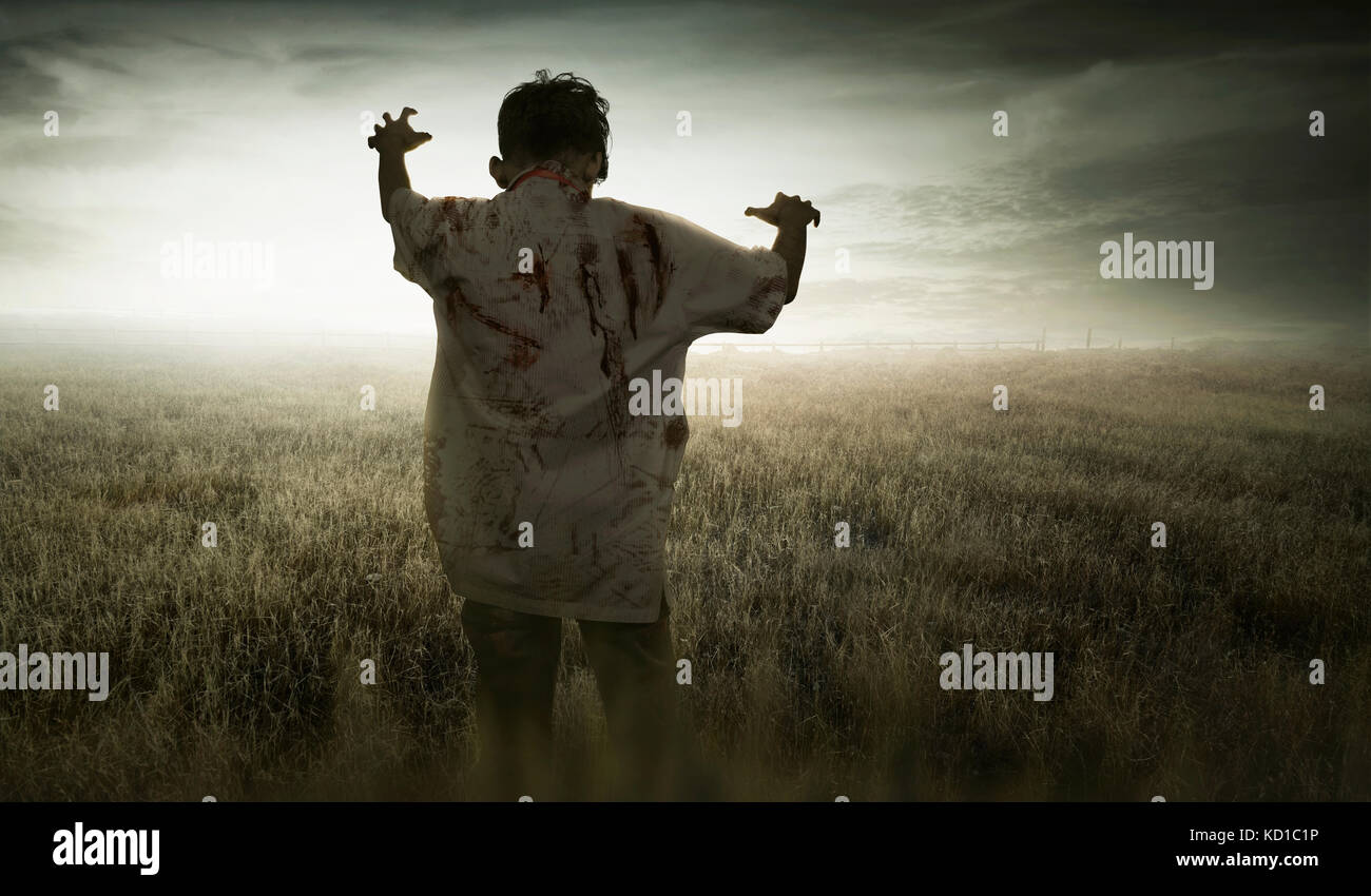 Wütend asiatischen zombie Mann mit Blut in seiner Kleidung stehen auf der Wiese Stockfoto