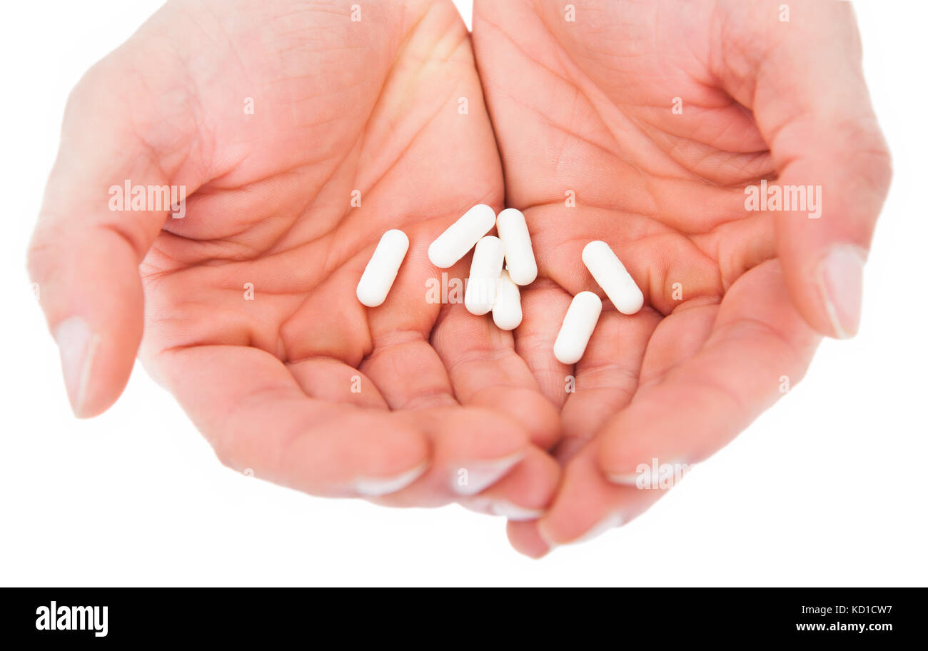 Nahaufnahme einer Hand, die Pillen einer Person auf weißem Hintergrund Stockfoto