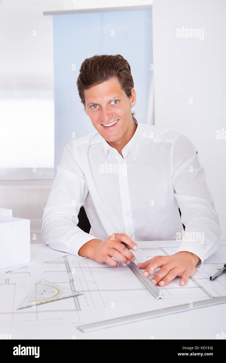 Portrait eines glücklichen jungen Architekten Zeichnung plan auf Blueprint Stockfoto