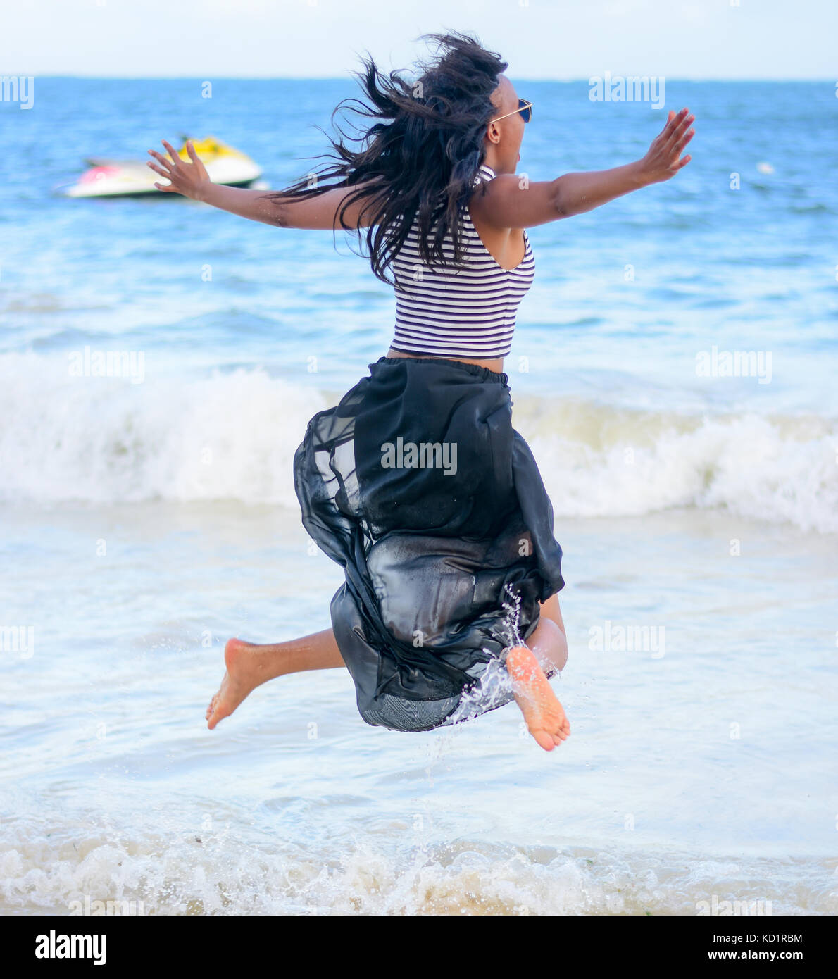 Jumping am Strand Stockfoto