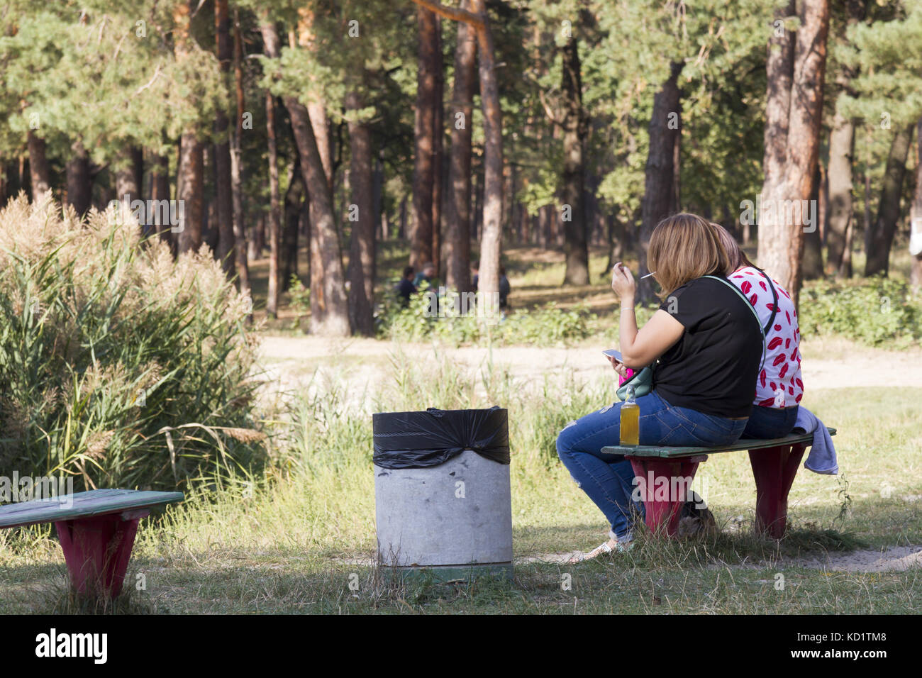 Zwei Frauen sitzen im Park und Rauchen Stockfoto