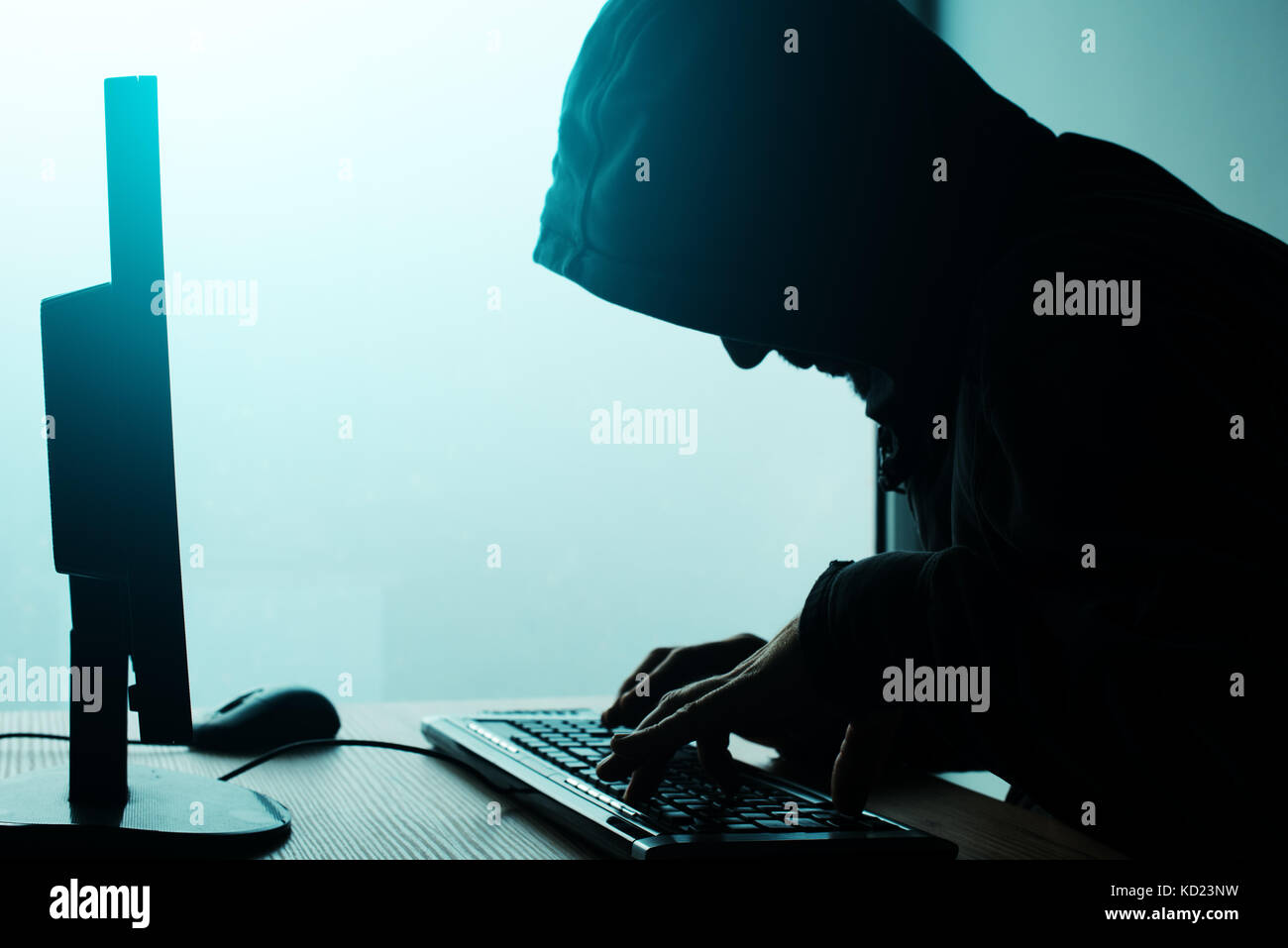 Hooded computer Hacker hacking Network. Männliche mit Schwarz mit Computer für Identitätsdiebstahl oder andere kriminelle Online-aktivitäten Hoodie. Stockfoto