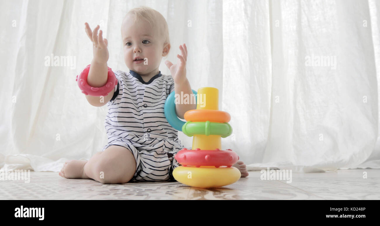 Adorable Baby mit Spielzeug spielen auf weißem Hintergrund Stockfoto