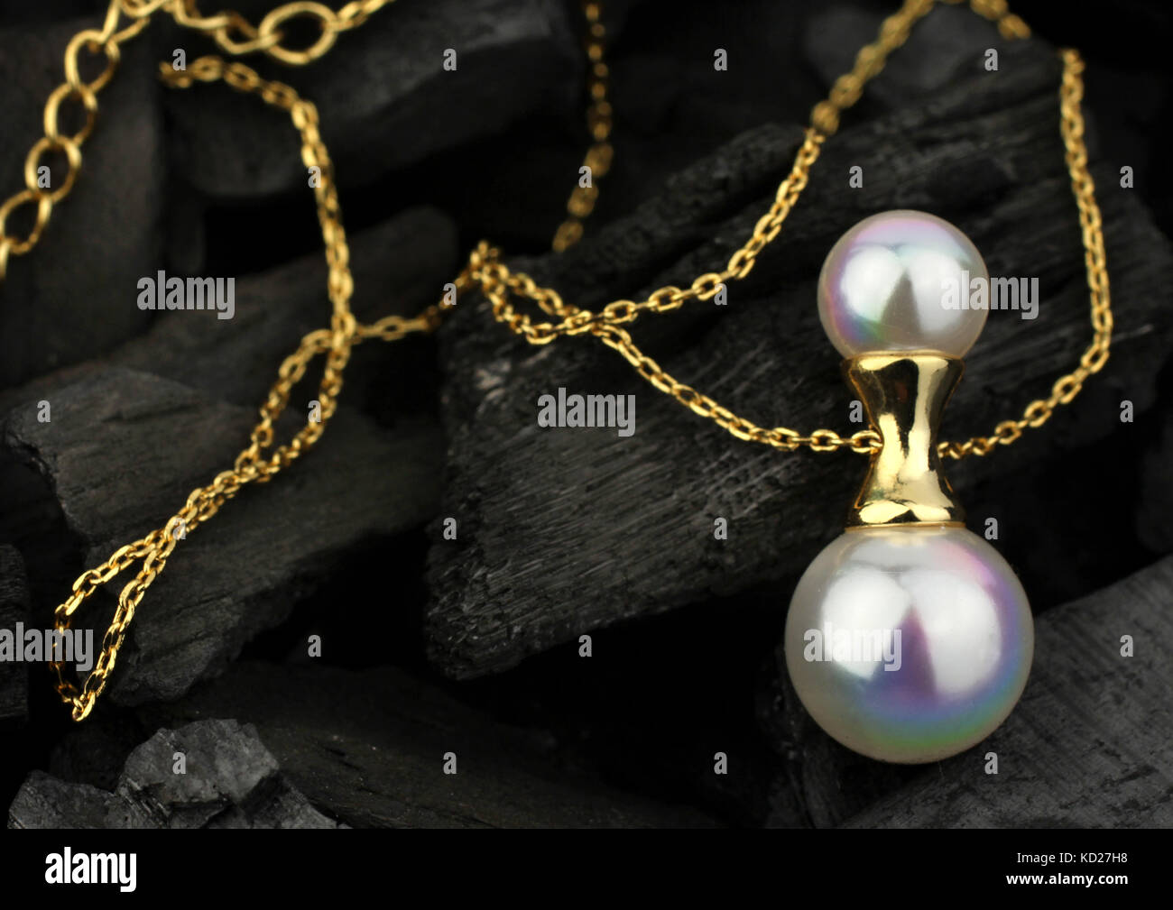 Goldene Schmuck Anhänger mit Perle auf dunklen Kohle Hintergrund, Soft Focus Stockfoto