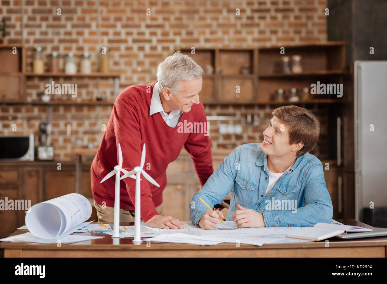 Junge Ingenieur diskutieren Blaupause mit seinem älteren Kollegen Stockfoto