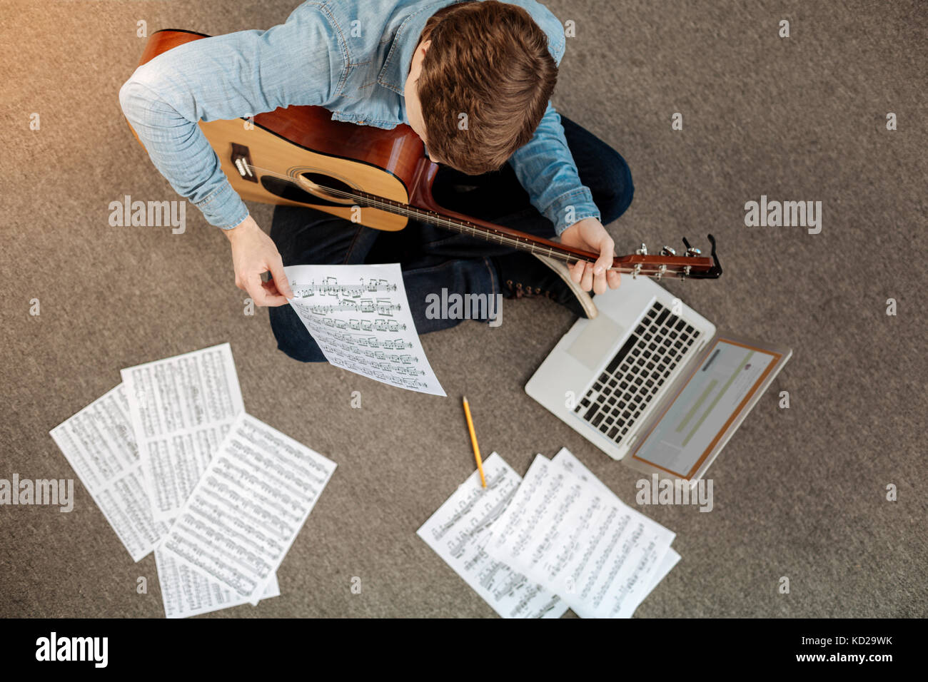 Blick von oben auf die jungen Mann lesen musikalische Notation Stockfoto