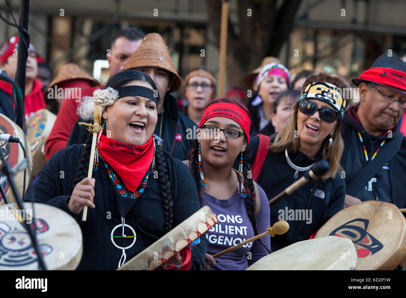 Seattle, Usa. Oktober 2017. Jennifer Fuentes (links) mit ihrer Tochter Ayanna (Mitte) trommelt während des Indigenous Peoples' Day Marsch and Celebration im Westlake Park. Fuentes führte zusammen mit dem Widerstand der indigenen Schwestern den marsch zum Rathaus von Seattle. Seattle hat den Tag der Indigenen statt des Kolumbus-Tages gefeiert, seit eine einstimmige stadtratswahl 2014 den Bundesfeiertag zu Ehren aller Indigenen umbenannte. Quelle: Paul Christian Gordon/Alamy Live News Stockfoto
