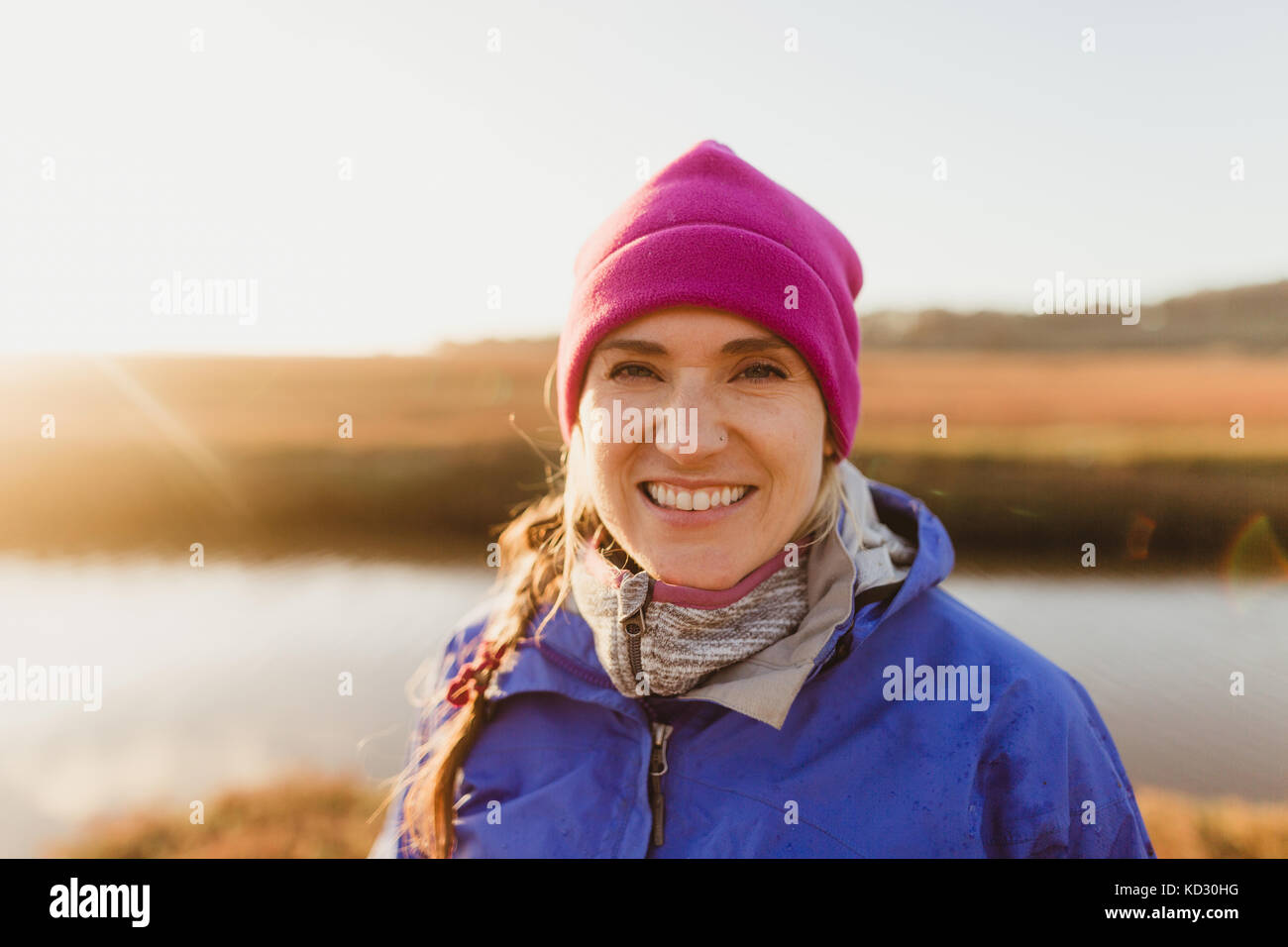 Portrait der Frau in rosa Hut am Flussufer bei Sonnenuntergang, Morro Bay, Kalifornien, USA Stockfoto