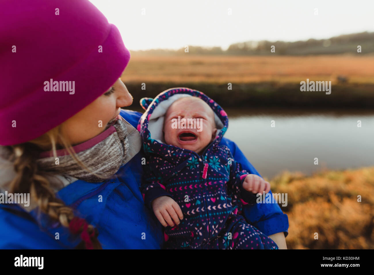 Mitte der erwachsenen Frau mit Baby schreien Tochter am Flussufer, Morro Bay, Kalifornien, USA Stockfoto