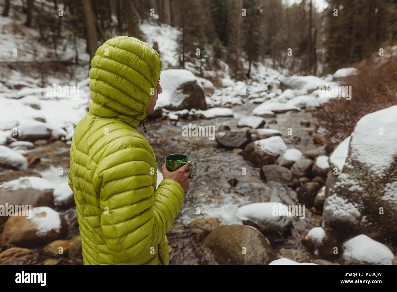 Junge männliche Wanderer mit Kaffee von verschneiten Wald Fluss, Sequoia National Park, Kalifornien, USA Stockfoto