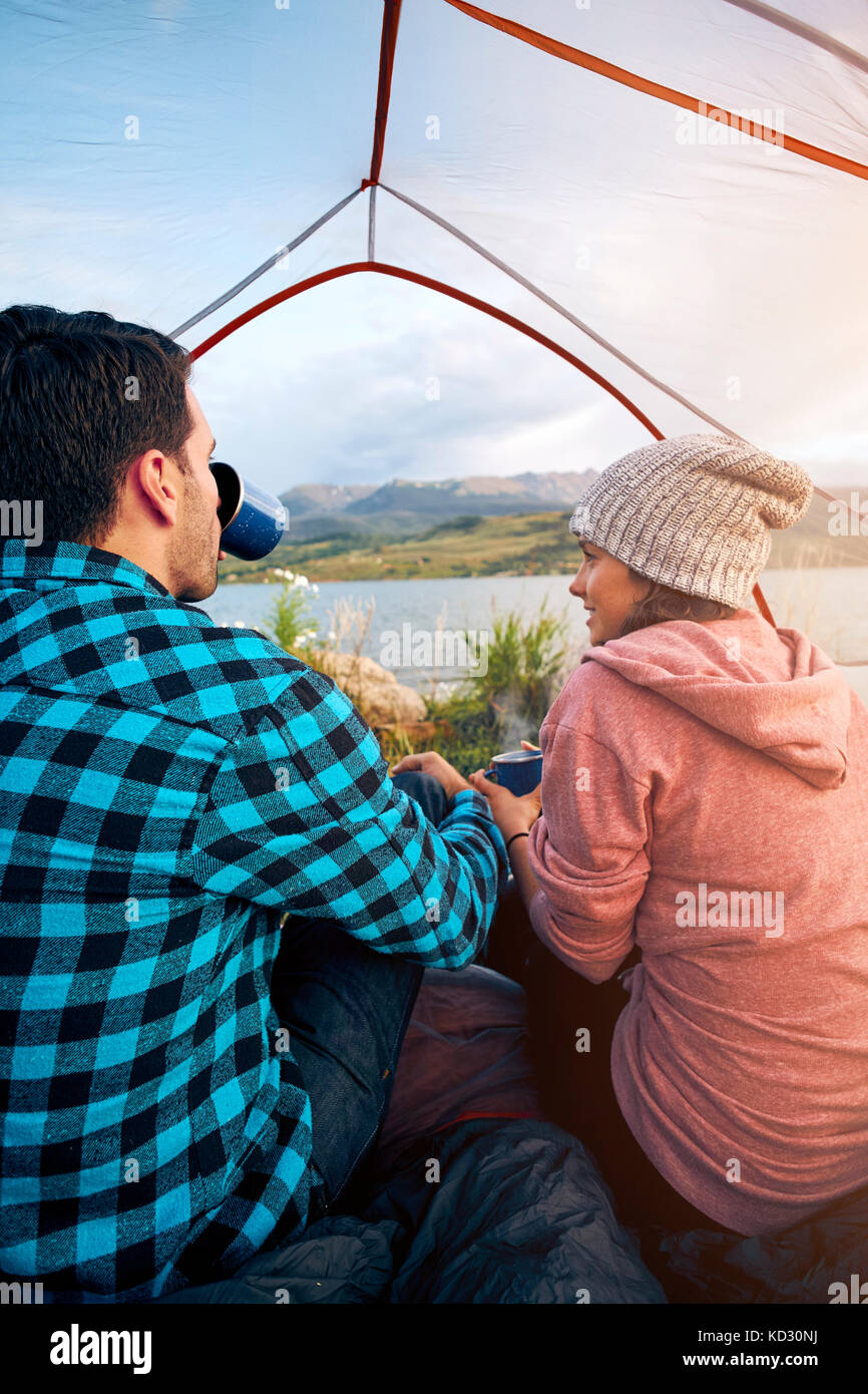 Paar im Zelt sitzen, trinken Sie heiße Getränke, in Aussicht, Heeney, Colorado, United States Stockfoto