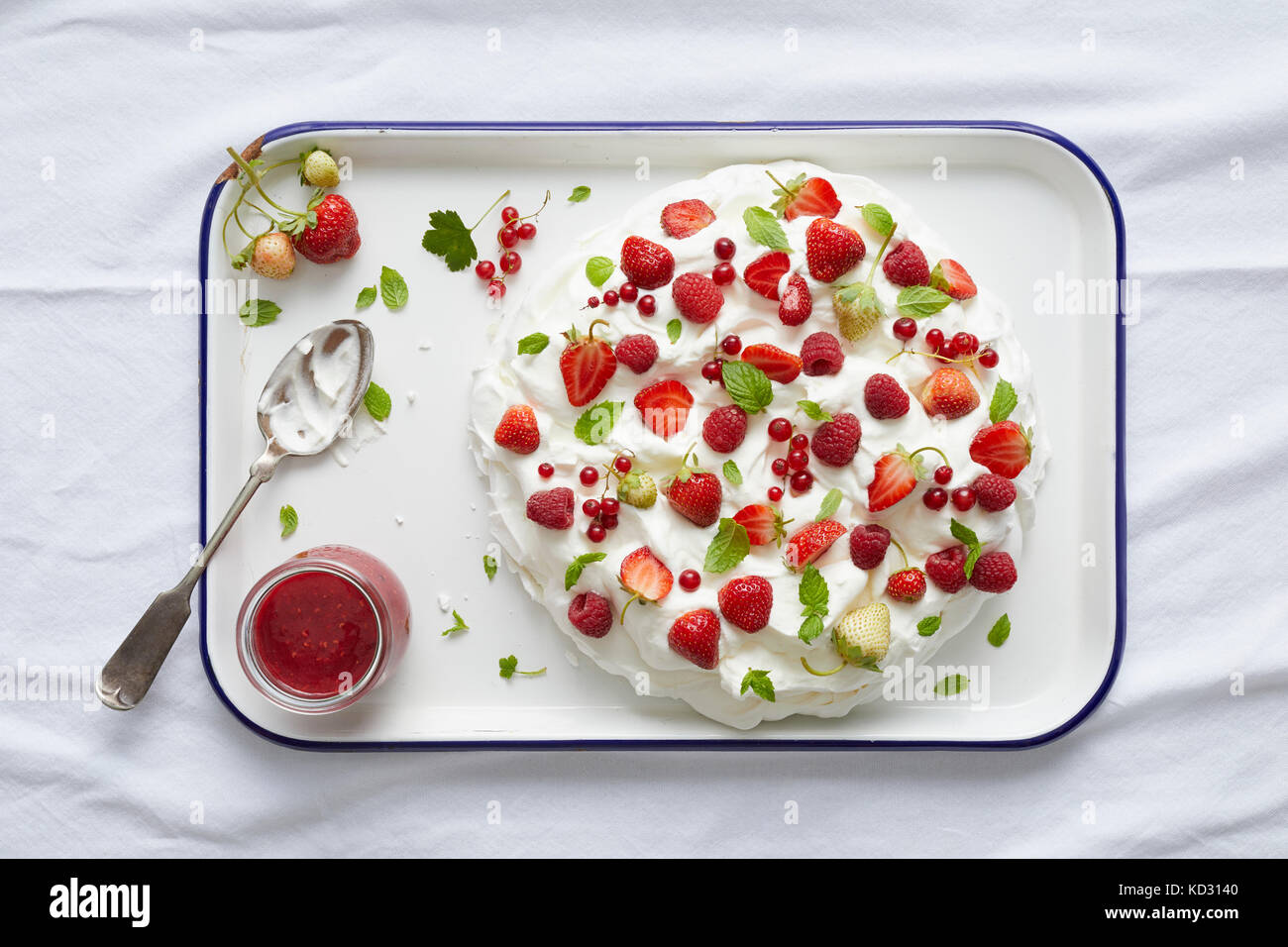Pavlova mit Johannisbeeren, Erdbeeren und frischer Minze auf serviertablett Stockfoto