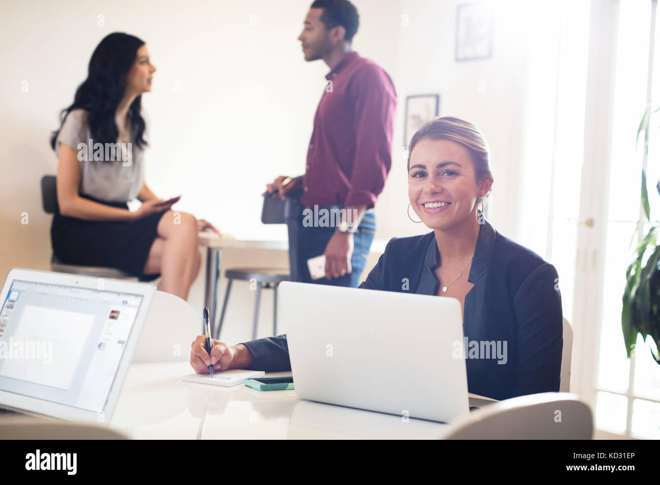 Porträt der jungen mit Laptop auf dem Schreibtisch Geschäftsfrau Stockfoto