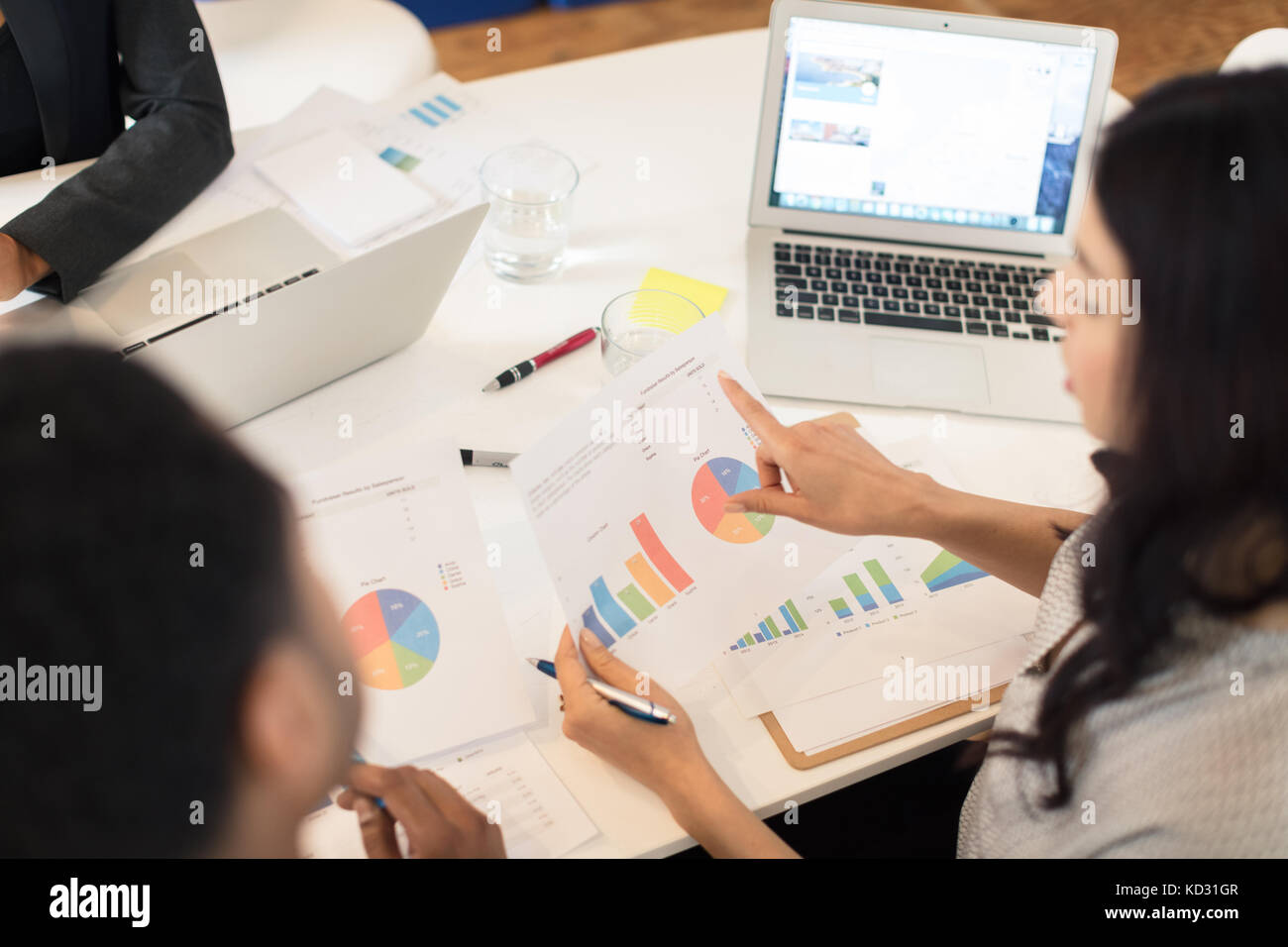 Geschäftsfrau auf Kreisdiagramme auf Tisch Stockfoto