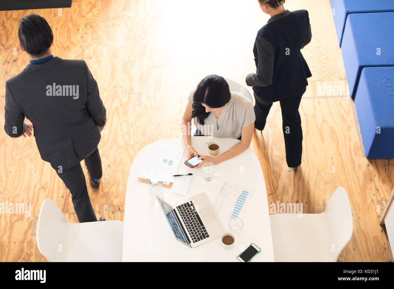 Ansicht von oben der jungen Geschäftsfrau am Smartphone im Büro Tabelle suchen Stockfoto