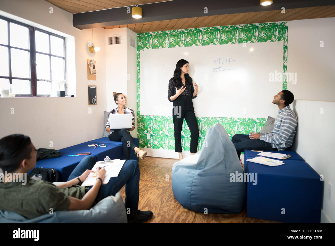 Junge Geschäftsfrau, die Whiteboard-präsentation in kreativen Tagungsraum Stockfoto