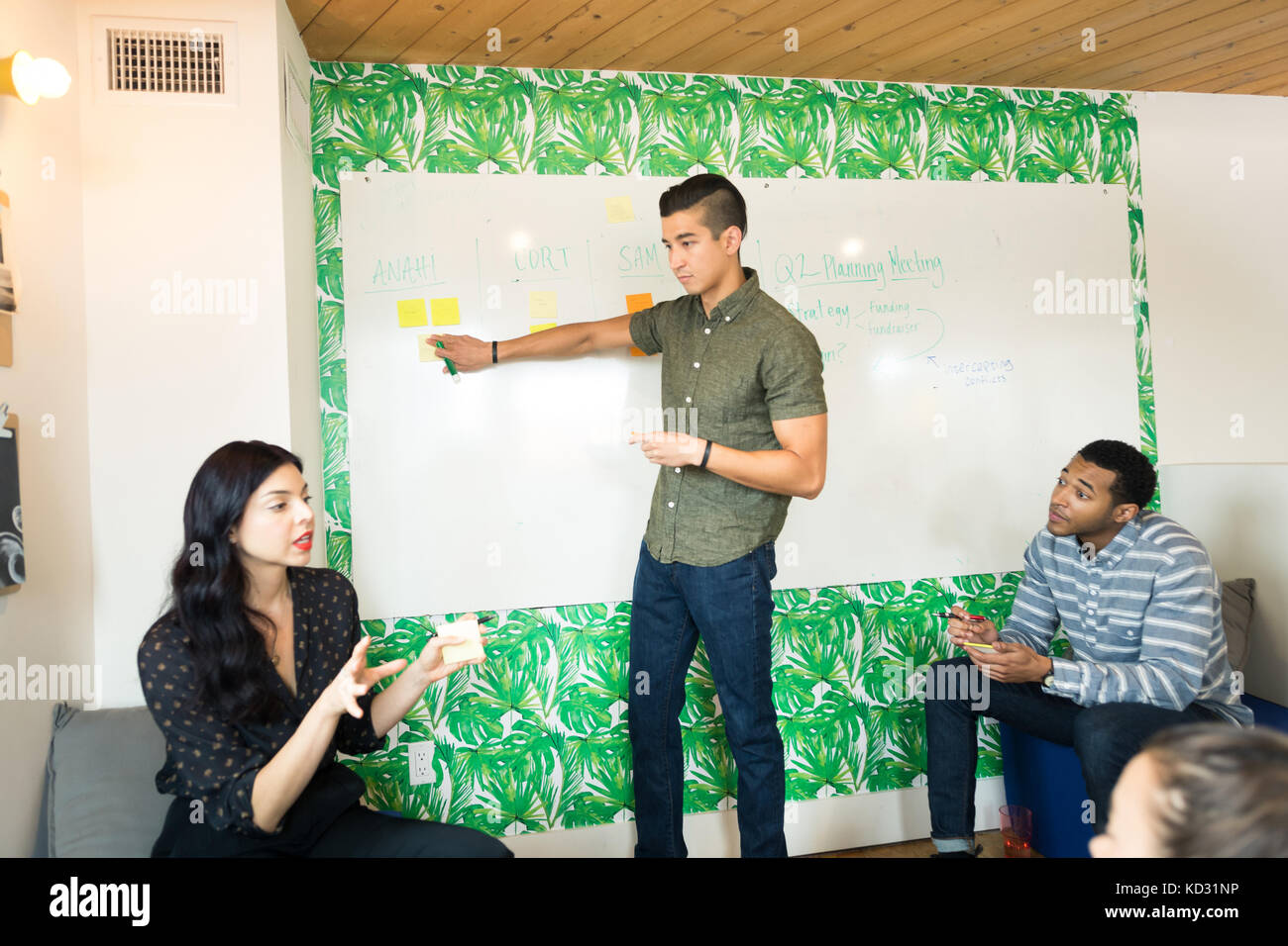 Junge Unternehmer am Whiteboard im kreativen Tagungsraum zeigen Stockfoto