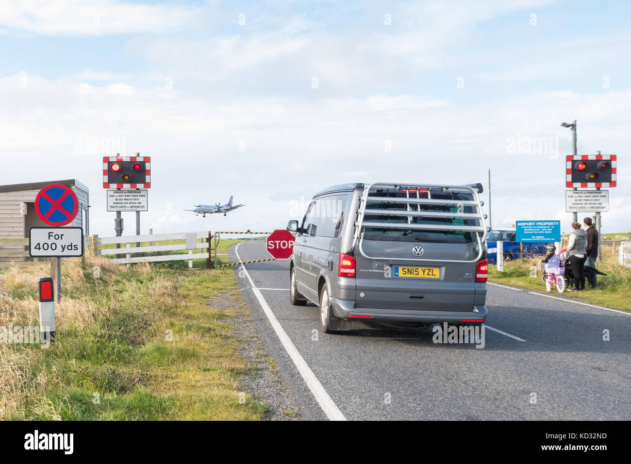 Sumburgh Airport - Flugzeug, das auf der Landebahn landet, die von einer Straße überquert wird, die von einem Bahnübergang kontrolliert wird, Shetland Islands, Schottland, Großbritannien Stockfoto