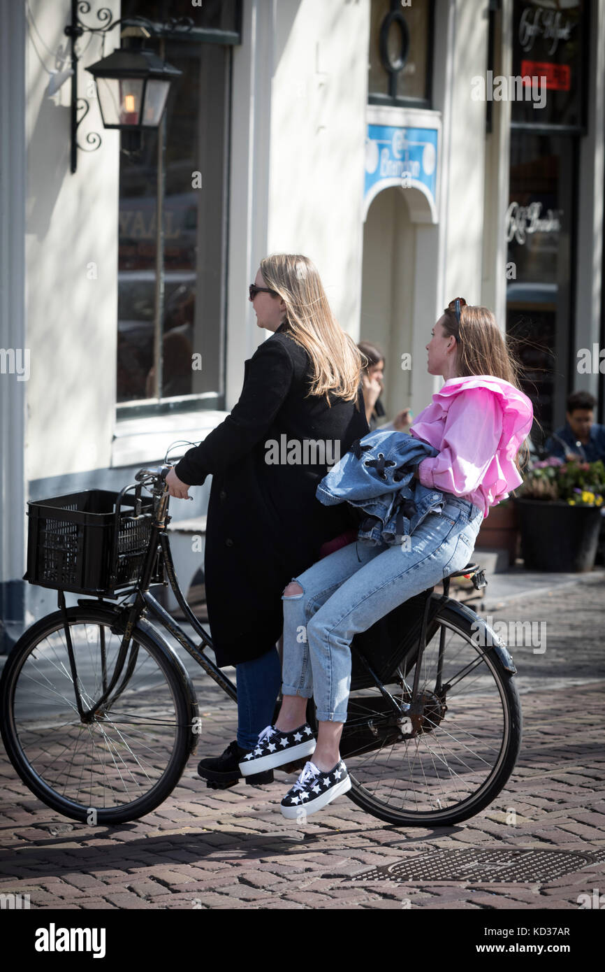 Zwei Frauen auf einem Fahrrad in Amsterdam in den Niederlanden Stockfoto