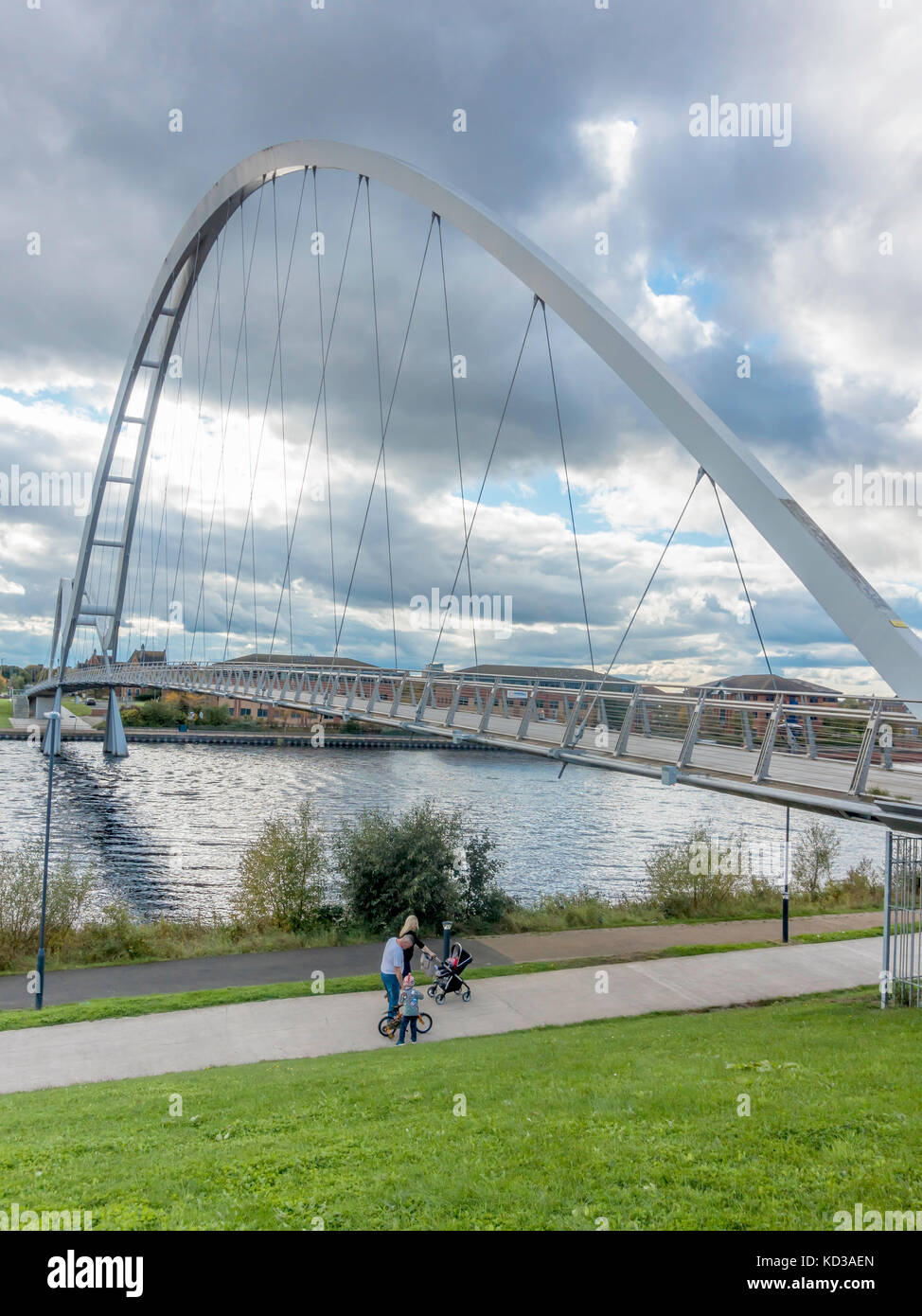 Eine Familie am nördlichen Ufer des Flusses Tees durch die Unendlichkeit Brücke für Fußgänger und Zyklus Kreuzung an der Stockton Stockfoto