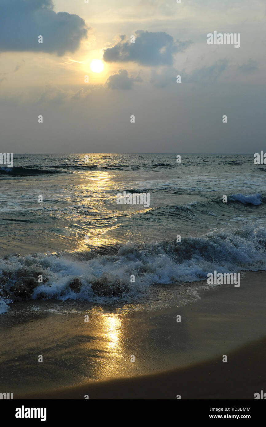 Sonnenuntergang am Arabischen Meer mit der Reflexion der Sonne auf dem nassen Sand Stockfoto