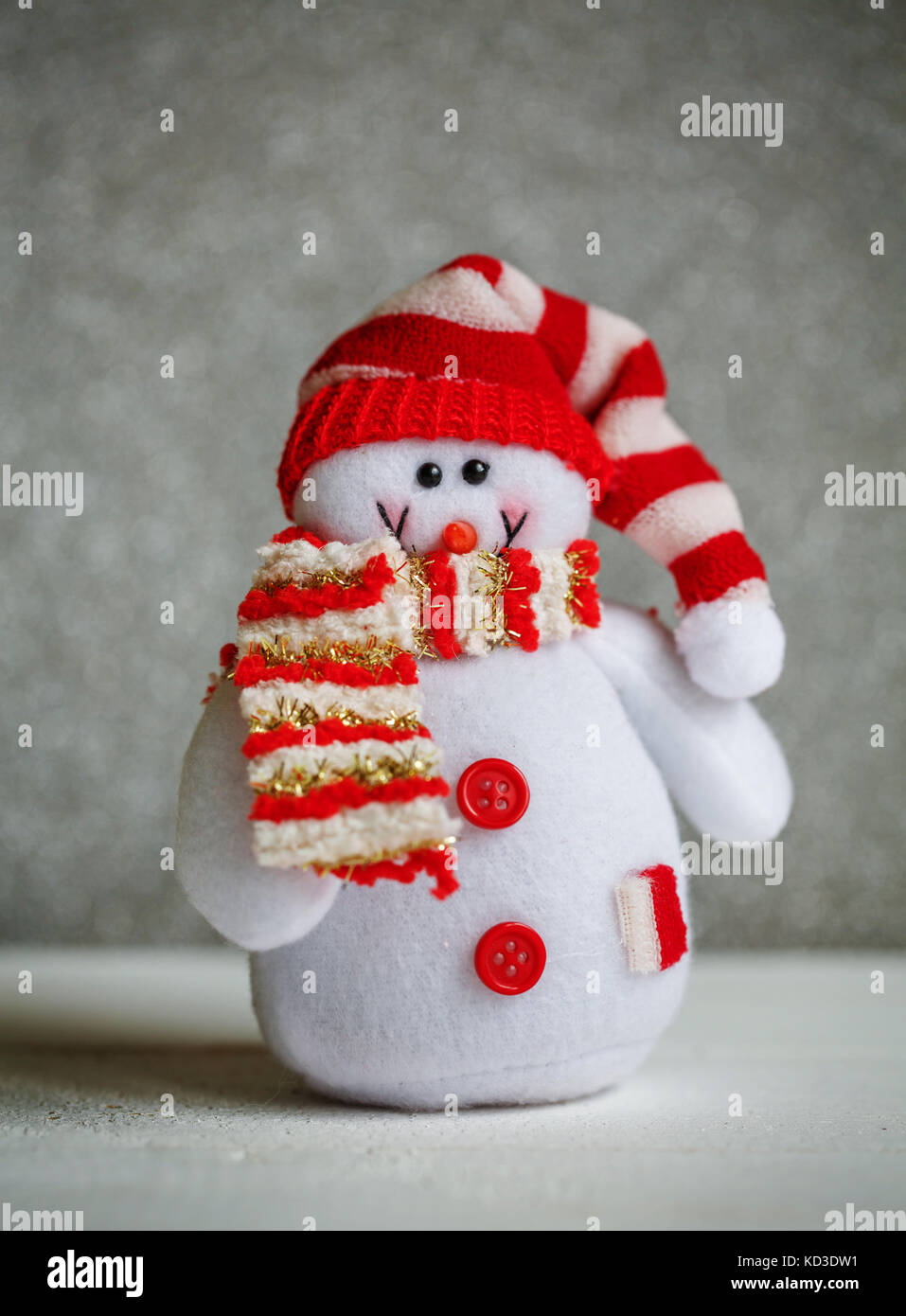 Lächelnd schneemann Spielzeug in Schal und Mütze bekleidet. Stockfoto