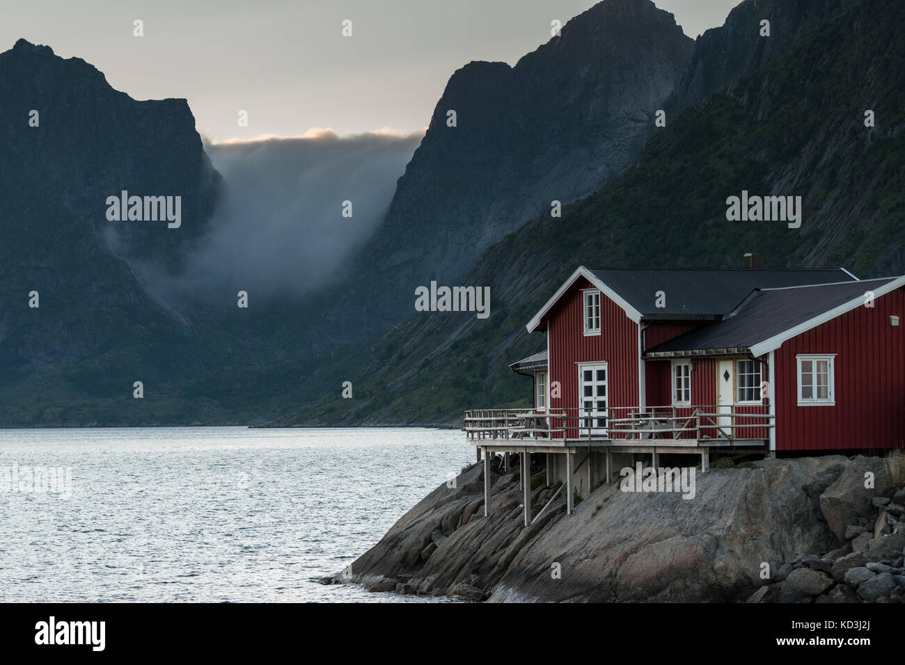 Traditionelle Fischer Rorbu, Hütte, Hütten, in Lofoten. majestätische Berge und Wolken im Hintergrund Stockfoto