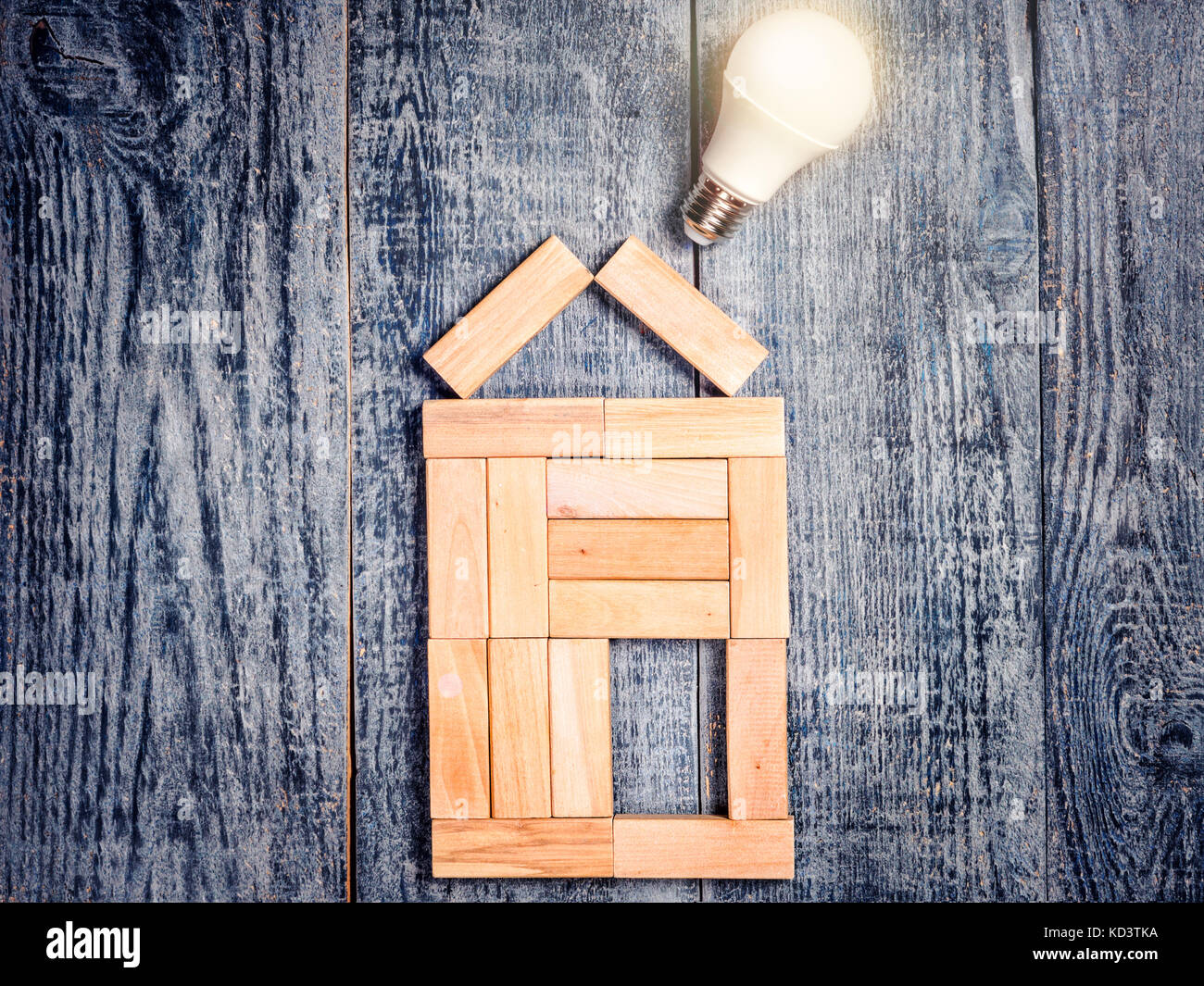 Form von House über Baum auf dunklem Hintergrund und LED-Lampe. Stockfoto