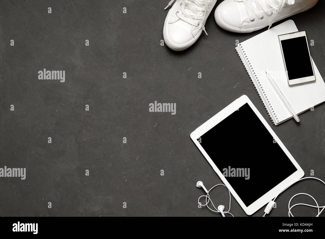 Flach der weißen Turnschuhen auf schwarzem Hintergrund mit Telefon, Kopfhörer, Tablet, kopieren Buch Stockfoto