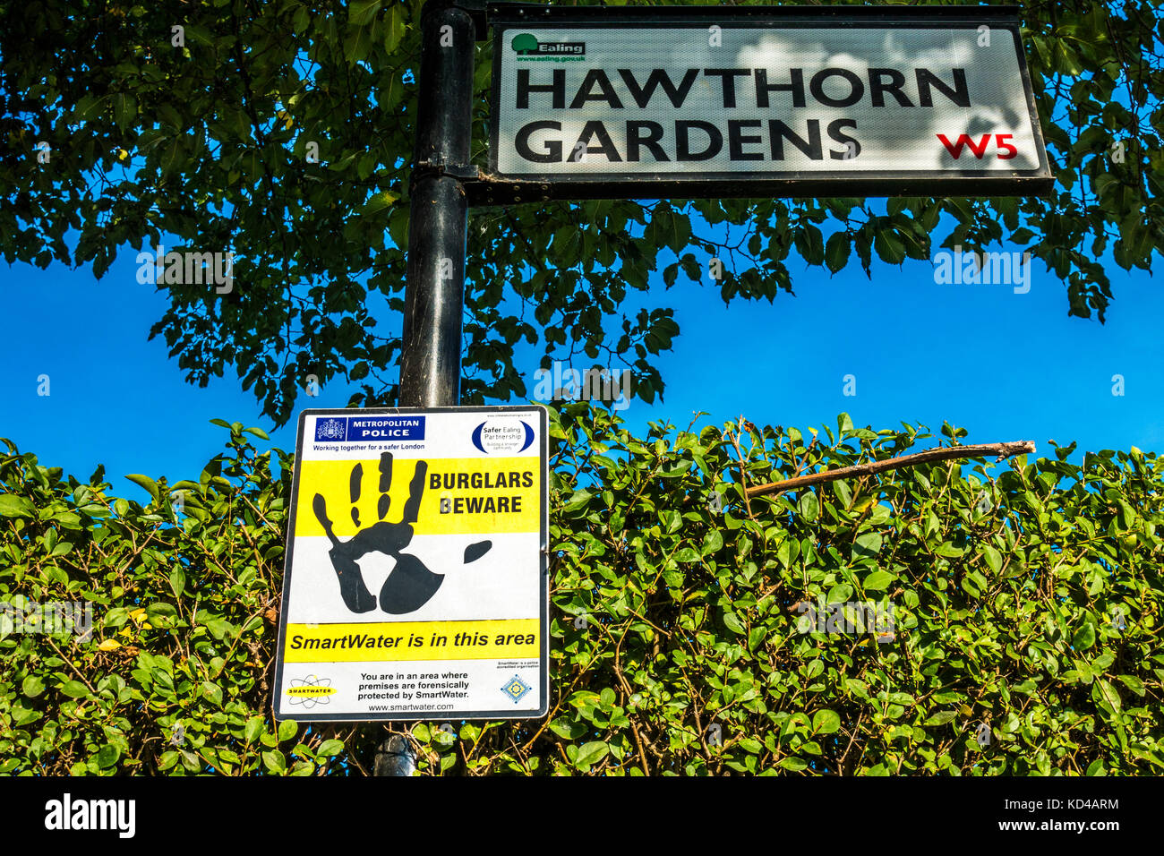 Ein 'Einbrecher' Vorsicht Warnschild auf, um die Aufmerksamkeit auf SmartWater nachvollziehbar Eigenschaft Kennzeichnung liegt in einer ruhigen Straße in South Ealing, London, England, UK. Stockfoto