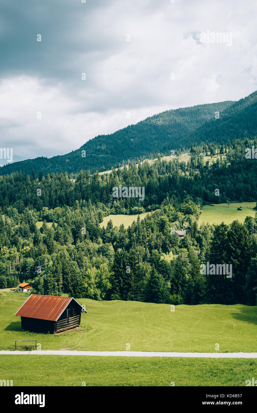 Landschaft der deutschen Alpen mit einer Holzhütte in einem Gras Feld Stockfoto
