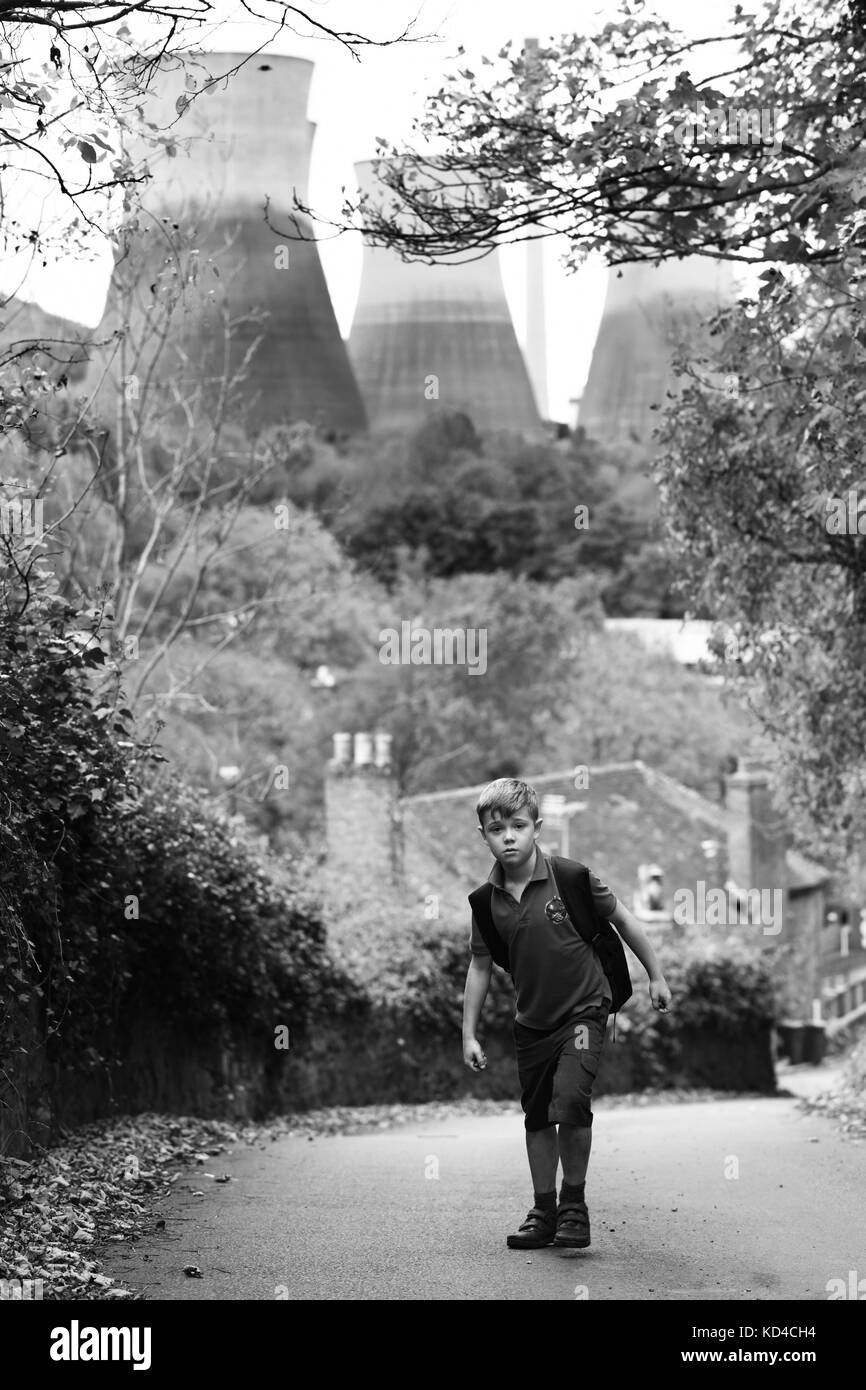 Kleiner Junge, der von der Schule auf einem steilen Hügel nach Hause geht. BILD VON DAVID BAGNALL Stockfoto