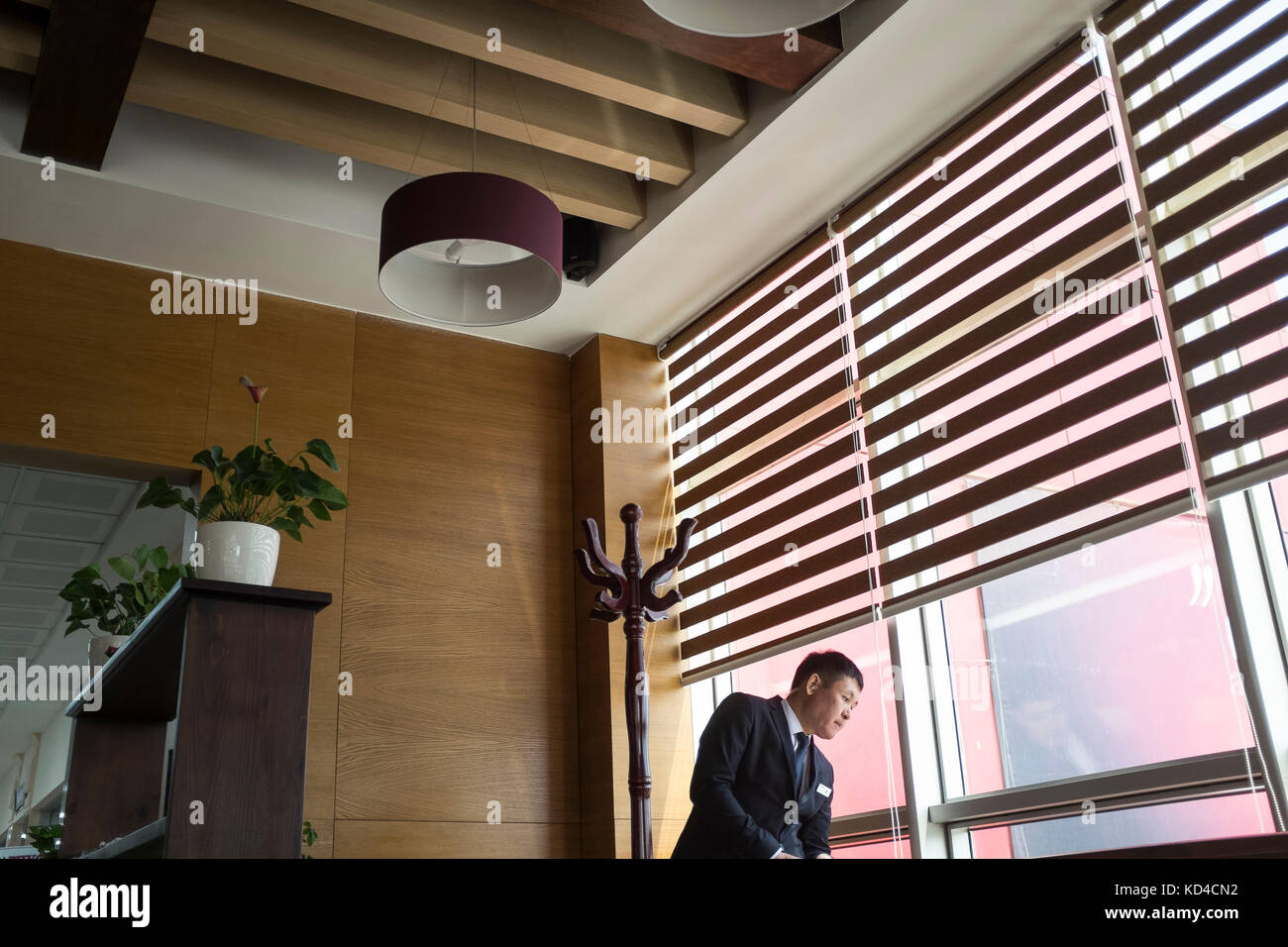 Ein Sicherheitsagent schaut in einem Café in Astana nach einem Fenster. Die Sicherheit ist eine Obzession und überall in Astana, Café; Geschäfte; Museum; Straßen Stockfoto