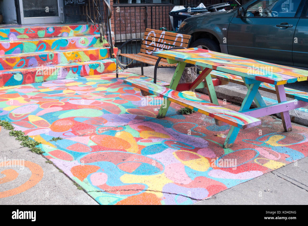 Farbenfroh Eingang der Gehweg, Treppen und Picknick Tisch vor einer Bar in Kensington Market in der Innenstadt von Toronto, Ontario, Kanada Stockfoto