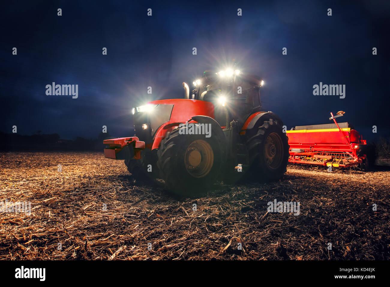 Traktor Vorbereitung land mit saatbeet Kultivator bei Nacht Stockfoto
